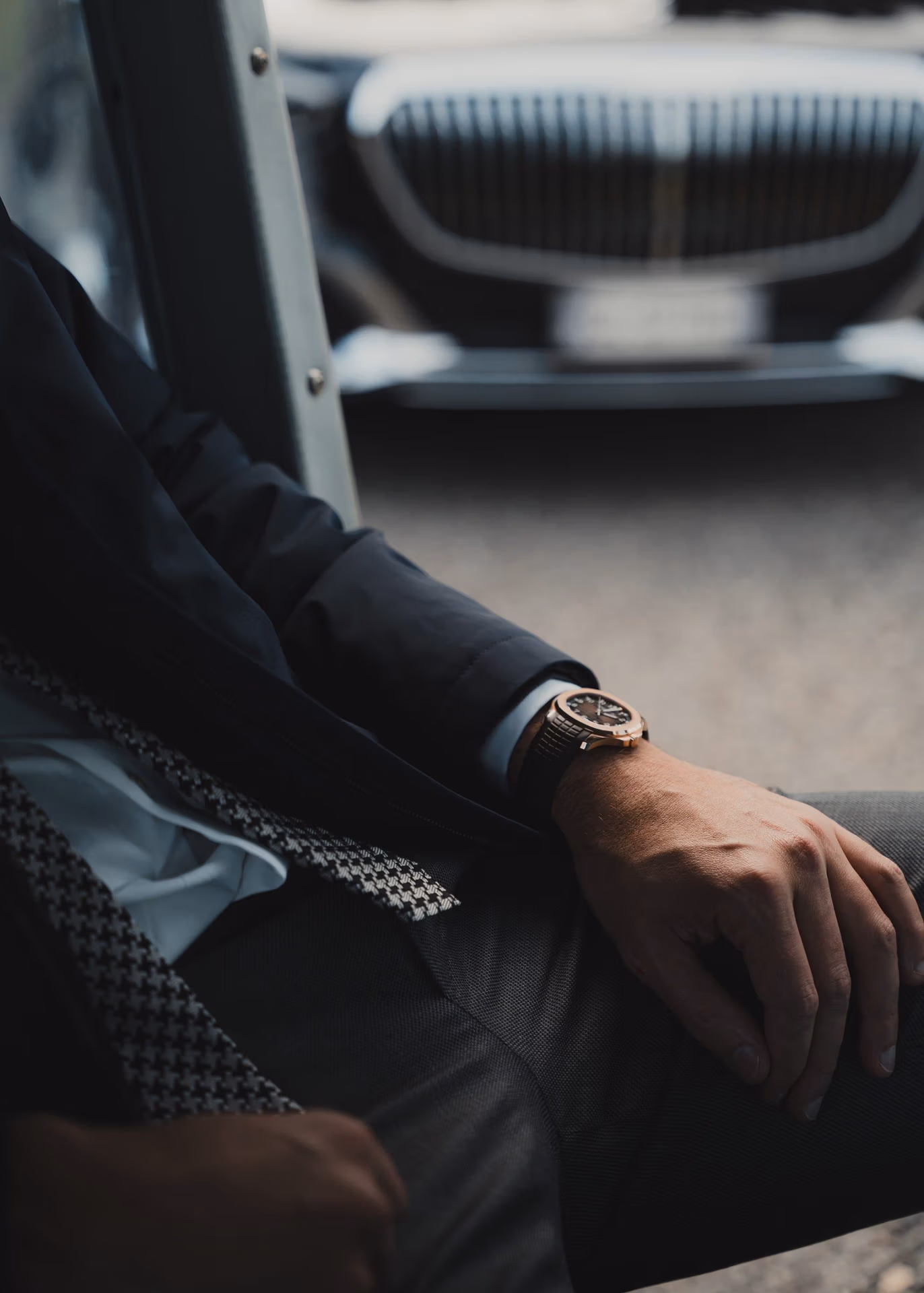 Gold wristwatch on the wrist of a man in a tailored jacket
